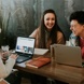 Colleagues laughing together over laptops